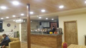 una cocina con encimera y gente en una habitación en PETRA Cabin Dorms Hostel en Wadi Musa