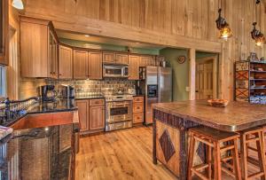 a large kitchen with wooden cabinets and a large island at West Dover Cabin with Game Room, 4 Mi to Mt Snow! in West Dover