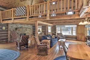 ein Wohnzimmer mit einem blauen Sofa und einer Treppe in der Unterkunft Log Cabin on the Wolf River with Private Hot Tub! in White Lake