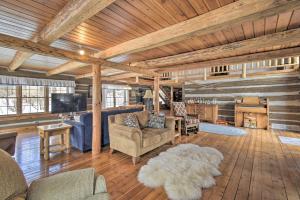 Il comprend un salon doté de plafonds en bois, d'un canapé et de chaises. dans l'établissement Log Cabin on the Wolf River with Private Hot Tub!, à White Lake