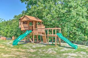 een houten speeltuin met een glijbaan en een speelhuis bij Kimberlys Hope Clark Apt on Farm with Pool Access in Clark