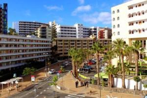 eine Stadt mit Gebäuden und Palmen und einer Straße in der Unterkunft in the heart of Playa del Inglés in San Bartolomé de Tirajana