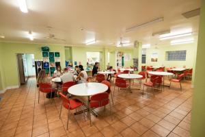 een klaslokaal met studenten aan tafels in een cafetaria bij YHA Newcastle Beach in Newcastle