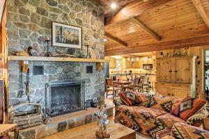 a living room with a stone fireplace and a table at Rustic Cozy Cabin on Island Lake with Fire Pit, Dock in Arago