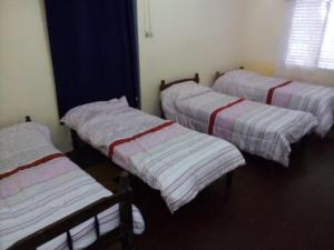 3 camas en una habitación con sábanas a rayas en MERCEDES CASA DEL HUM, en Mercedes