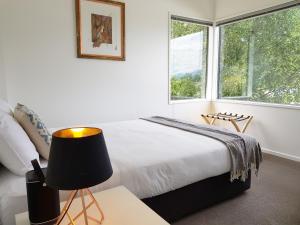 a bedroom with a bed with a lamp and a window at qTownPad in Queenstown