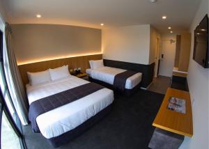 The Godley Hotel tesisinde bir odada yatak veya yataklar