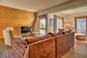 a living room with a large couch and a fireplace at Condo with Hot Tub, Mins to Story Land and Cranmore! in North Conway