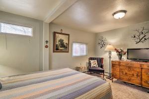 a bedroom with a bed and a flat screen tv at Colorful Bungalow By Pikes PeakandGarden of the Gods in Manitou Springs