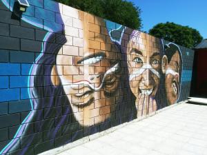un mural de dos personas en una pared en Mi lugar Serrano 3 en Valle Hermoso