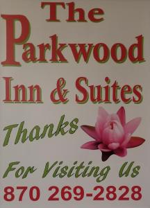 a sign for the park wood inn and suites with a pink flower at The Parkwood Inn & Suites in Mountain View