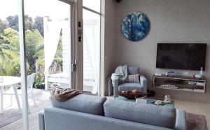 a living room with a blue couch and a tv at The Bay Lodge in Pohara