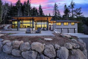 a house with a stone wall in front of it at Pahtos Retreat Luxe White Salmon Home Hot Tub in White Salmon