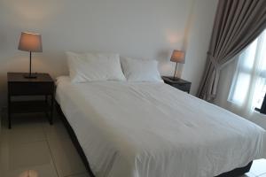 1 dormitorio con 1 cama blanca con 2 mesitas de noche y 2 lámparas en Lodge Alpha LaVista at Emira Residence Shah Alam, en Shah Alam