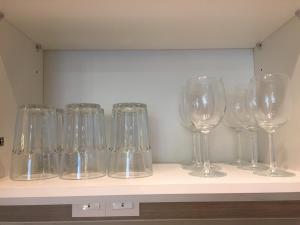 une rangée de verres à vin assis sur une étagère dans l'établissement Lodge Alpha LaVista at Emira Residence Shah Alam, à Shah Alam