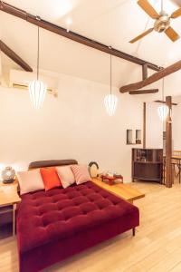 a red couch in a living room with a ceiling at back alley residence Hibi in Osaka