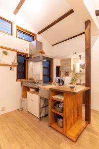 a large kitchen with wooden counters and a counter top at back alley residence Hibi in Osaka