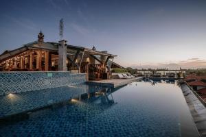 una grande piscina con un edificio sullo sfondo di ARTOTEL Sanur Bali a Sanur