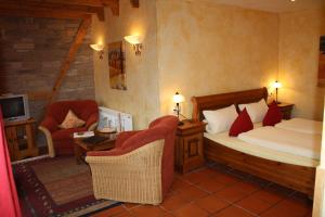 a bedroom with a bed and a couch and a chair at Weingut Magdalenenhof in Rüdesheim am Rhein