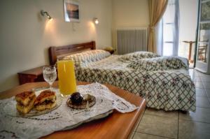 a room with two beds and a table with a tray of food at Vassiliki Studios in Andros