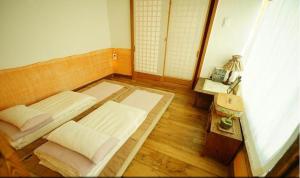 a room with two beds and a table and a lamp at Hanok Story Guesthouse in Jeonju