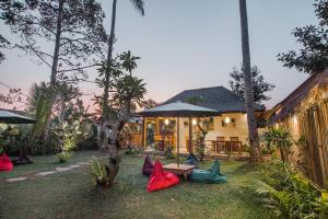 une maison avec un jardin doté de chaises rouges et bleues dans l'établissement Abimana Ubud, à Ubud