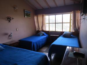 Hotel Portón De Ocetá في مونغوي: غرفة بسريرين ونافذة