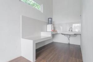 a kitchen with white walls and a sink at RedDoorz Resort Syariah near D'Castello Ciater Subang in Subang +57 photos