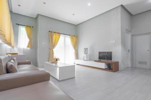 a living room with a couch and a tv at RedDoorz Resort Syariah near D'Castello Ciater Subang in Subang