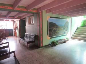 Hotel Portón De Ocetá في مونغوي: غرفة معيشة بها لوحة على الحائط والدرج