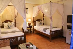 a bedroom with two beds with mosquito nets at Changmoi House (Little Village) in Chiang Mai