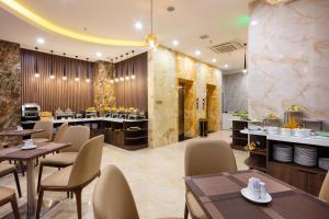 ニャチャンにあるAmber Hotel managed by HTのテーブルと椅子が備わるレストラン