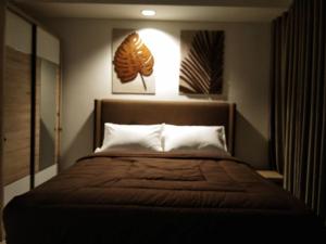 um quarto com uma cama grande e um cobertor castanho em Bogor Icon Apartment em Kedunghalang