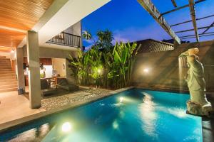 a swimming pool in the backyard of a house at Kuta Legian Villa by Kamara in Legian