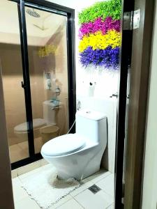 a bathroom with a toilet and a shower with flowers at DMCI Bristle Ridge Condo 318 Cozy 2 Bedroom Unit in Baguio +41 photos