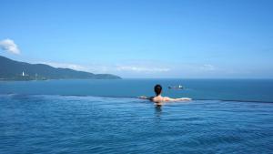 a person swimming in the water in the ocean at Chicland Danang Beach Hotel in Danang