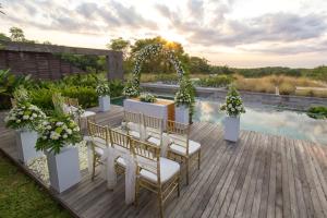an outdoor wedding ceremony on a deck with a pool at Hideaway Villas Bali - Uluwatu by Kanaan Hospitality in Uluwatu +76 photos