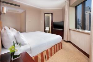 a hotel room with a large bed and a television at Jianguo Hotel Shanghai in Shanghai