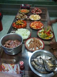 a table with many plates of food on it at New Dambulla City Hostel in Dambulla