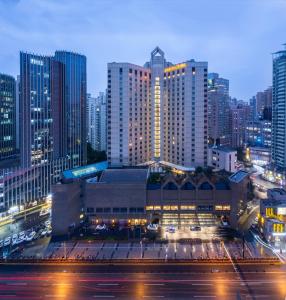 un grand bâtiment dans une ville la nuit dans l'établissement Jianguo Hotel Shanghai, à Shanghai