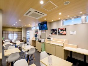 uma sala de espera com mesas e cadeiras numa clínica em Tabist Hotel Asiato Namba em Osaka