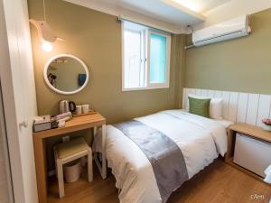 Kleines Zimmer mit einem Bett, einem Schreibtisch und einem Spiegel in der Unterkunft Hotel QB Dongdaemun Gallery in Seoul