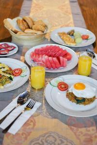 a table with plates of breakfast foods and drinks at Baliana Villa Legian in Legian