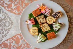 a white plate of food on a table at Baliana Villa Legian in Legian