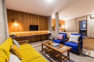 a hotel room with a couch and chairs and a tv at Kuta Legian Villa by Kamara in Legian