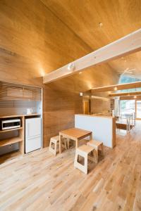 a kitchen with wooden walls and a table and benches at Mt.Takao Base Camp in Hachioji