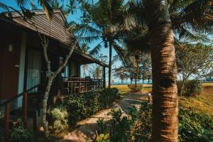 a house with a palm tree next to a sidewalk at Nana Beach Hotel & Resort in Pathiu