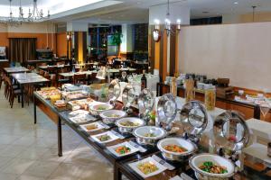 a buffet line with plates of food in a restaurant at Miyako Hotel Amagasaki in Amagasaki