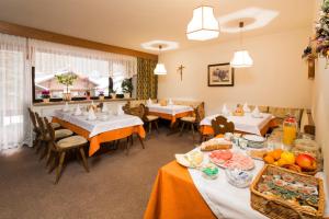 a restaurant with tables and chairs with food on them at Ciasa Iris in Colfosco