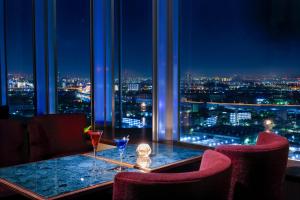 a restaurant with a table with two wine glasses at Miyako Hotel Amagasaki in Amagasaki